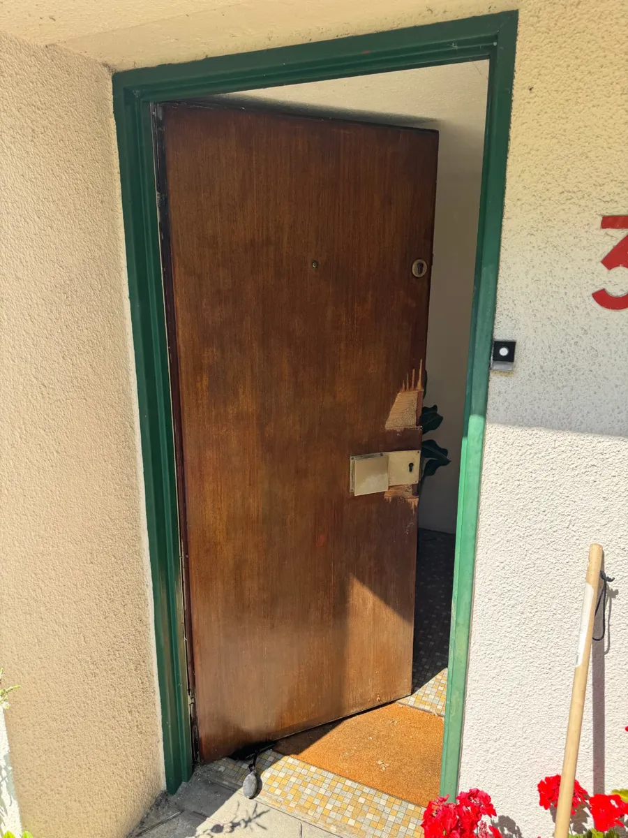 Ancienne porte d'entrée en bois abîmée avant remplacement